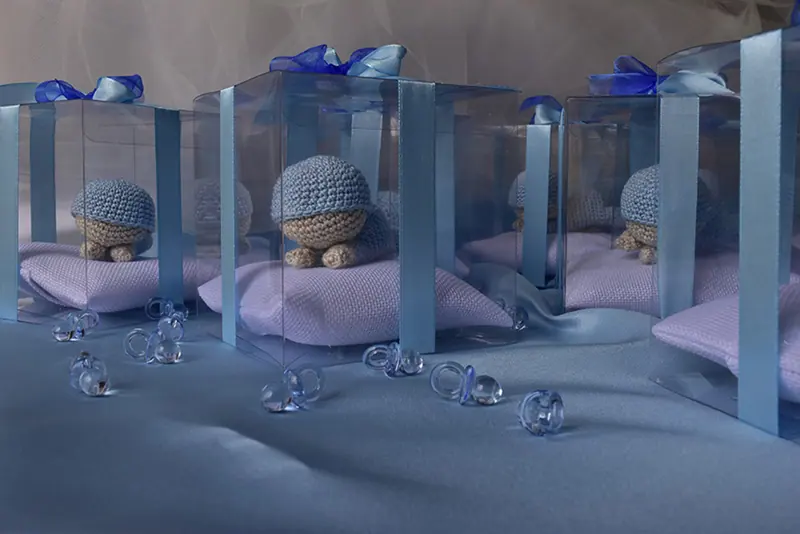 Bomboniere amigurumi in scatole trasparenti con nastri azzurri