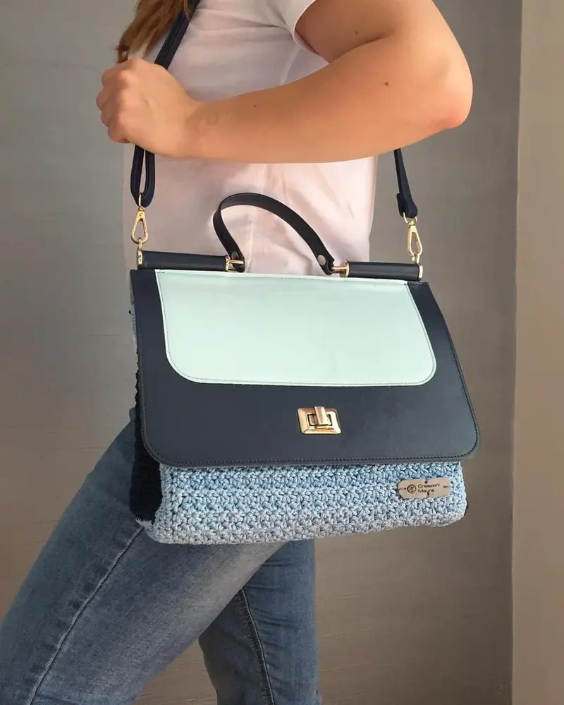 Borsa a tracolla blu e azzurra all'uncinetto, indossata