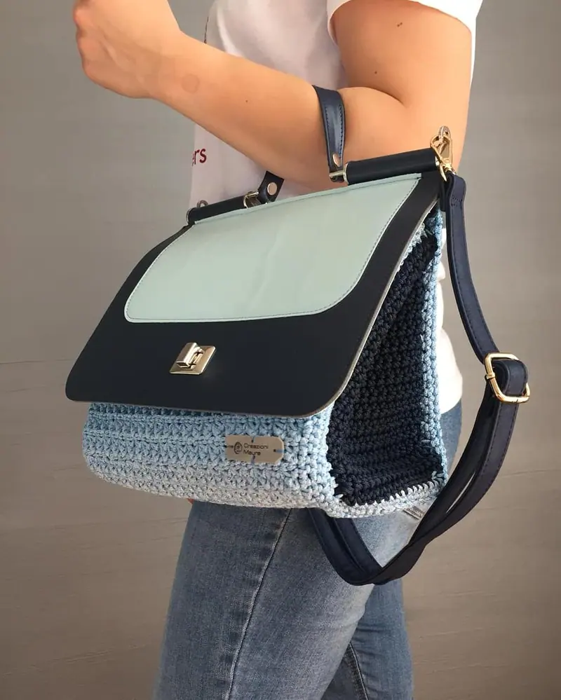 Borsa a tracolla blu e azzurra all'uncinetto, indossata